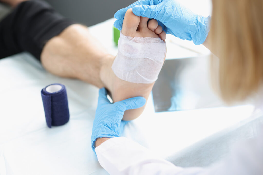Doctor hand touches and examines wound on leg. Medical concept