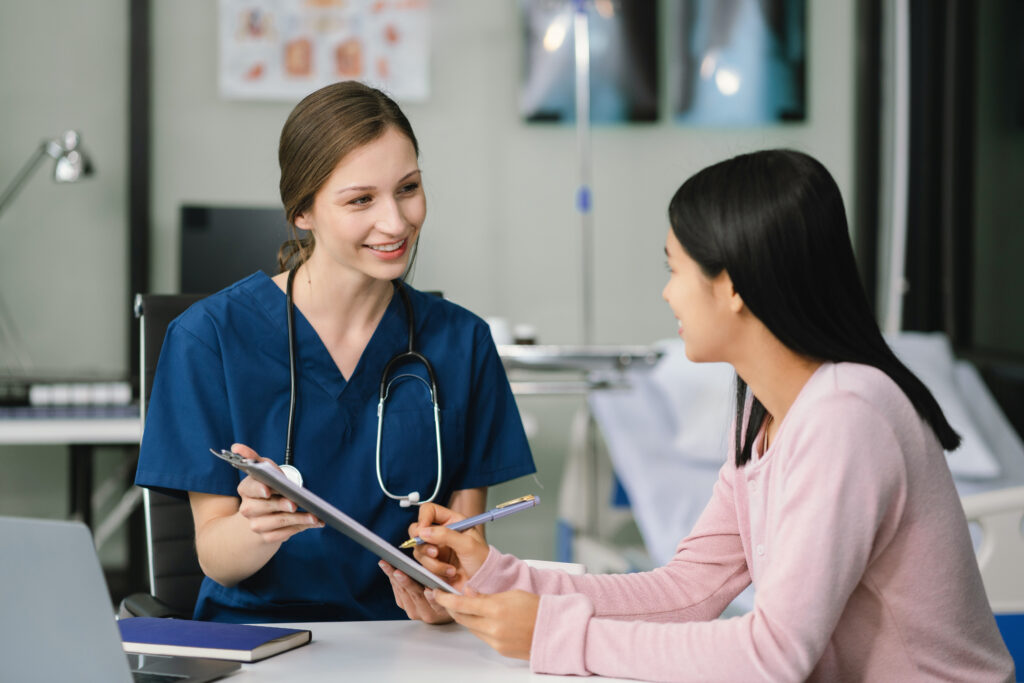 Female doctor and patient are talking and consulting at the table in a medical clinic or hospital health service.